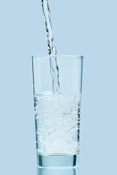 Wasser gießen. Frisches sauberes Trinkwasser ins Glas gießen. — Stockfoto