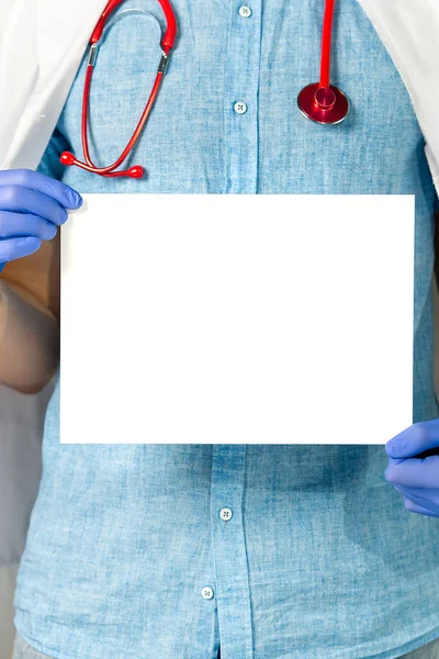 Médico segurando em mãos banner branco em branco, mockup — Fotografia de Stock