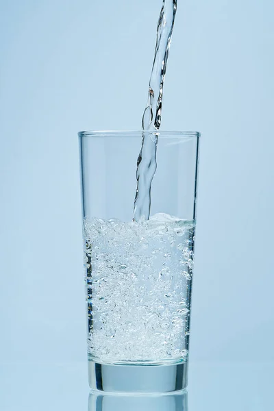 A deitar água. Despejar água potável fresca e limpa em vidro. — Fotografia de Stock
