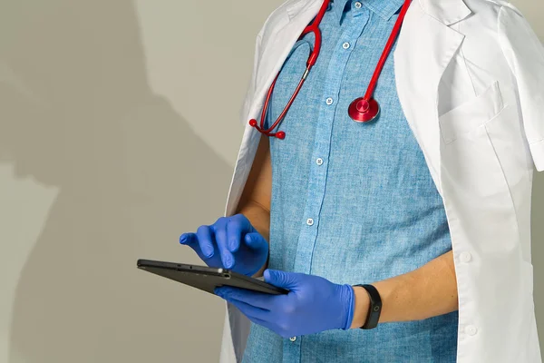 The doctor takes notes in the tablet. remote or distance medicine concept