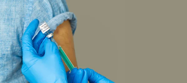 Läkaren slår in vaccinet i en spruta. en sjuksköterska med ett vaccin och en spruta i händerna — Stockfoto
