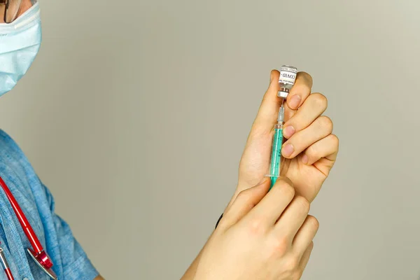 Lékař vytočí vakcínu do injekční stříkačky. zdravotní sestra s vakcínou a injekční stříkačkou v rukou — Stock fotografie