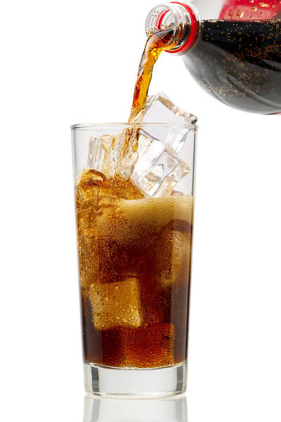 Pouring Cola to glass with ice cubes isolated on white