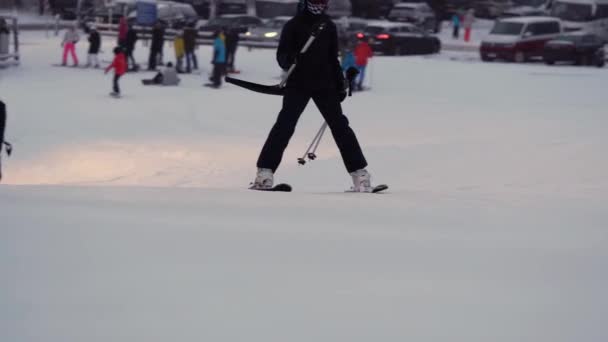 Narciarze korzystający z wyciągów narciarskich w zimowy wieczór, nocne jazdy na nartach — Wideo stockowe