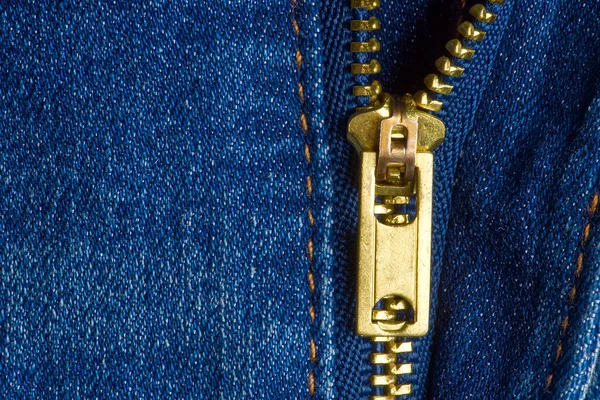 Half open ritsblauwe ritssluiting op een blauwe jeans. jeans macro textuur achtergrond. — Stockfoto