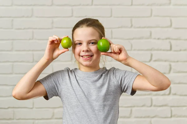 Menina feliz se divertindo e cobrindo seus olhos com limão, alimentação saudável, comida orgânica, dieta de frutas, conceito — Fotografia de Stock