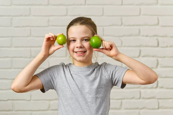 Felice ragazza divertendosi e coprendo gli occhi con lime, mangiare sano, cibo biologico, dieta di frutta, concetto — Foto Stock