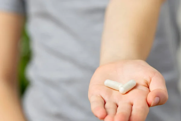 Дівчина рука з білими таблетками таблетки і склянка води — стокове фото