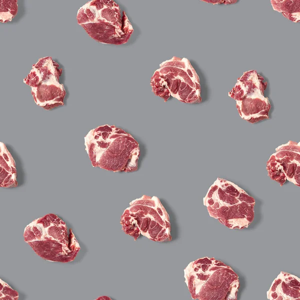 Patrón sin costura con rebanadas de carne de cerdo cruda sobre fondo gris, patrón de alimentos — Foto de Stock