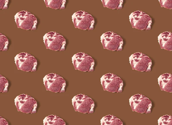 Безшовний візерунок з сирими шматочками свинячого м'яса на коричневому фоні, візерунок їжі — стокове фото