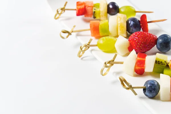 Collations fraîches de fruits d'été sur brochettes de bambou, isolées sur blanc — Photo