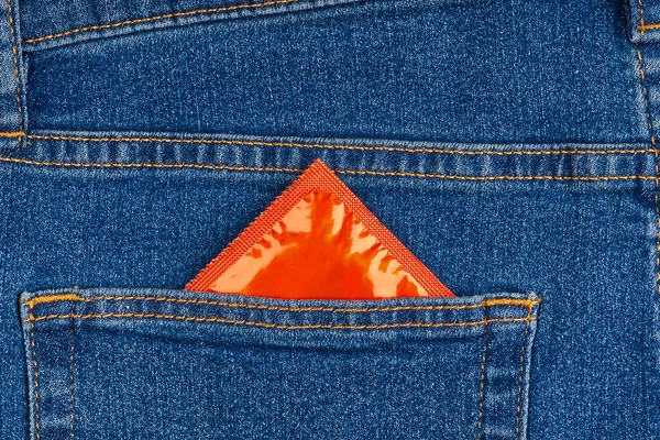 Preservativo nella tasca posteriore dei jeans blu — Foto Stock