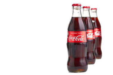 Estonya, Tallinn - 14.02.2021: Beyaz üzerine izole edilmiş cam bir şişe içinde Coca-Cola Classic. Cam şişede üç şişe Coca-Cola.