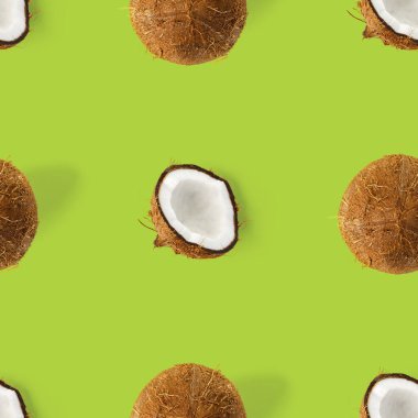 Hindistan cevizi aralıksız desen. Yeşil arka planda izole edilmiş hindistan cevizi olan tropik soyut bir arka plan. düz yat.