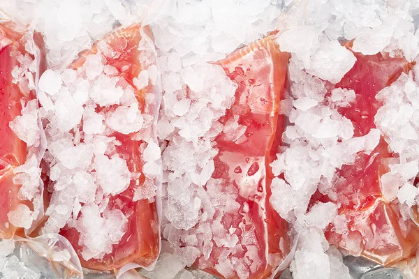 Frozen Tuna steak vacuum with ice on the counter the fishmarket. healfy food and nutrition concept