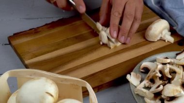 Erkekler mutfak masasında bıçakla şampiyonları kesiyor. Mantar pişirme konsepti