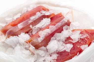 Plastik torbada buzlu donmuş ton balıklı biftek vakumu, taze yiyecek teslimatı konsepti. deniz ürünleri