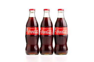 Estonya, Tallinn - 14.02.2021: Beyaz üzerine izole edilmiş cam bir şişe içinde Coca-Cola Classic. Üç şişe Coca-Cola.