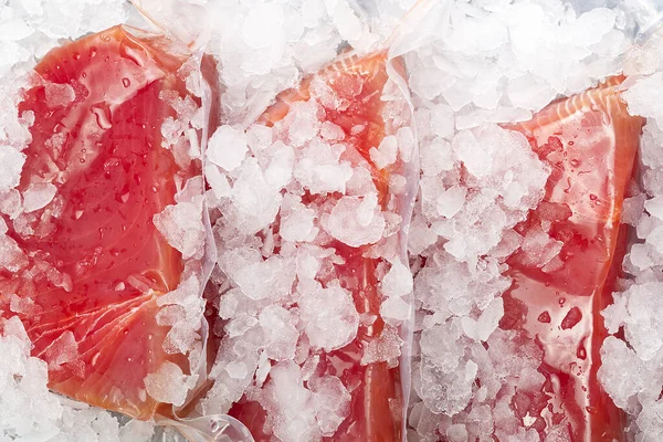 Frozen Tuna steak vacuum with ice on the counter the fishmarket. healfy food and nutrition concept