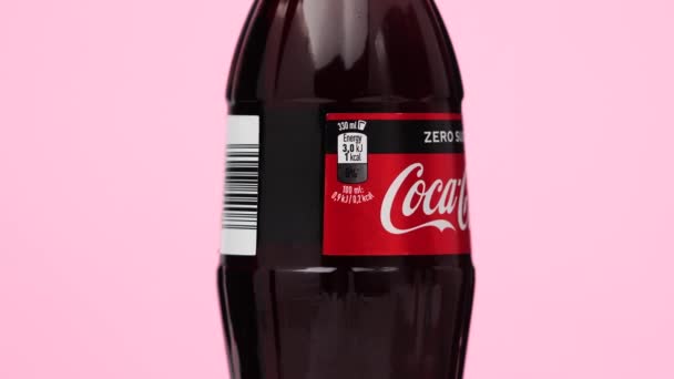 Estonia, Tallinn - marzo 2021: bottiglia di vetro coca-cola soda zero drink di zucchero ruotante su fondo rosa isolato. — Video Stock