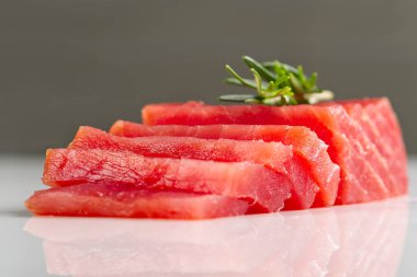 Ton balıklı saşimi. Taze sarı yüzgeçli ton balığı bifteği beyaz bir masa. Mavi yüzgeçli ton balığı madalyonları.