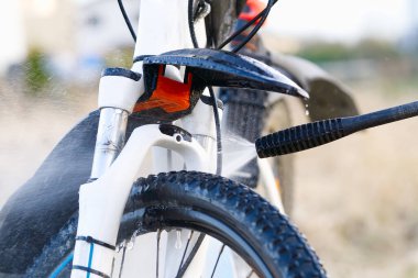 Arka bahçede bisiklet yıkama. Bisiklet sezonu için bahar hazırlıkları. Bisiklet bakımı, bisiklet yıkama