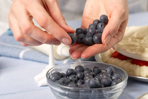 Pastry chef lays blueberries on strawberry marshmallow cake — Stock Photo, Image
