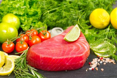 Çiğ ton balığı, ton balığı, sebzeli ton balığı. Deniz mahsulleriyle sağlıklı besleniyoruz, evde pişiriyoruz. Siyah taşın üzerinde balık eti düzeni