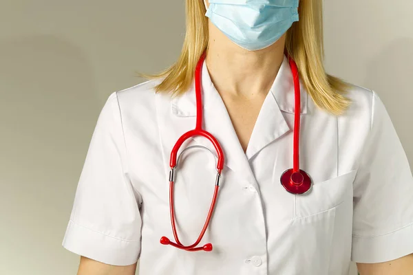 Лікар у медичній захисній масці та костюмі на бежевому фоні. Ніякого обличчя. жінка — стокове фото