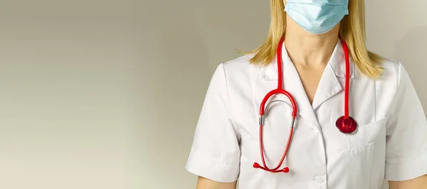 Dokter in medisch beschermend masker en pak op beige achtergrond. Geen gezicht. vrouw — Stockfoto