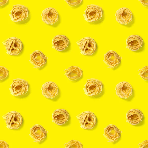 イタリアのパスタタリアテッレのシームレスなパターン。生パスタフェットチーネポップアートの背景フラットレイ。黄色に隔離されたイタリアの生の巣パスタ — ストック写真