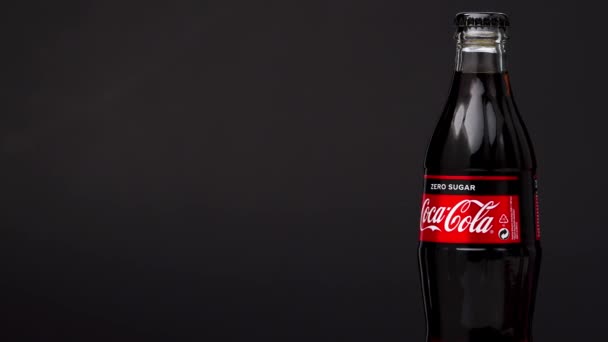 Estland, Tallinn - mars 2021: glasflaska coca-cola läsk noll socker dryck roterande på isolerad mörk svart bakgrund. — Stockvideo