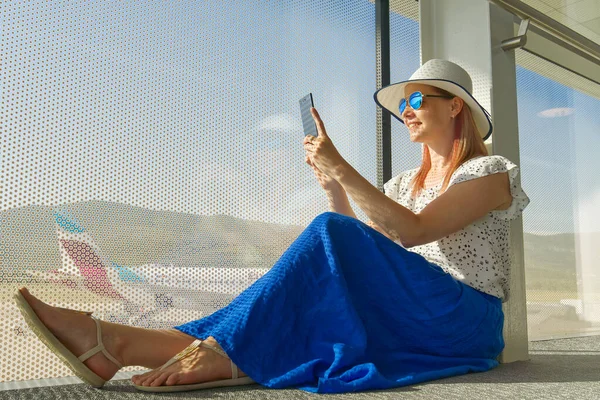 Female freelancer at airport. woman working with smartphone in airport until departure.