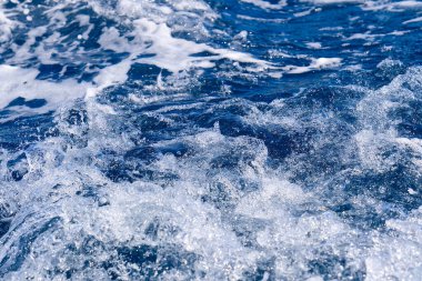 Arka planda beyaz dalga olan soyut mavi deniz suyu. Adreyatik denizi, mavi Akdeniz.