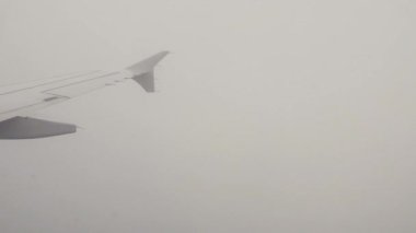 Uçak kanadı bulutların üzerinde uçuyor..