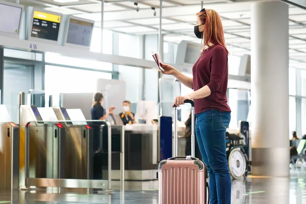 Mladá žena s ochrannou maskou, pasem a letenkami na mezinárodní letiště — Stock fotografie