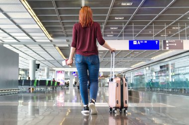 Uluslararası havaalanında ya da modern tren istasyonunda bavulu olan kadın yolcu.