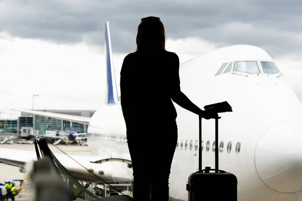 Schwarze Frauensilhouette mit Blick auf Flugzeuge in der Flughafenhalle - verpasstes oder gestrichenes Flugkonzept. — Stockfoto