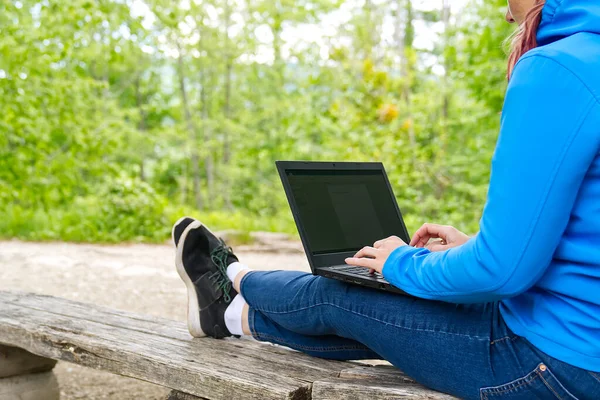 Fiatal nő, női szabadúszó dolgozik laptop Gyönyörű kilátás nyílik az erdőre és a tóra. — Stock Fotó