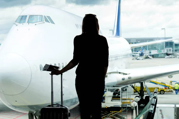 Schwarze Frauensilhouette mit Blick auf Flugzeuge in der Flughafenhalle - verpasstes oder gestrichenes Flugkonzept. — Stockfoto