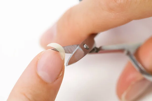 Cuidado casero de uñas. Una chica corta un frágil clavo roto. concepto de uñas frágiles — Foto de Stock