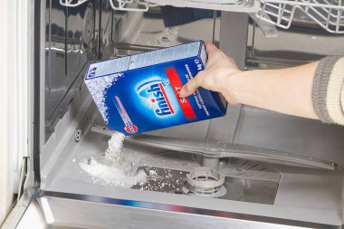 Estonya, Tallinn, 21.01.2021 Bulaşık makinesine tuz ekleyin. Bulaşık makinası tuzu eklemeyi bitirin ölçekli birikintileri önlemek için