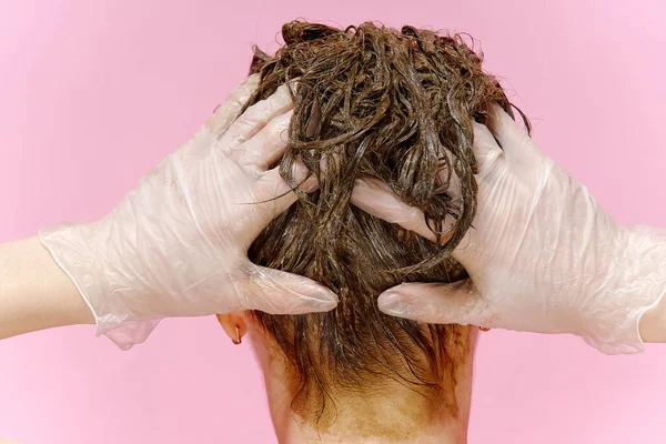 Przemysł kosmetyczny w czasach pandemii koronawirusów. młoda kobieta w rękawiczkach zostaje w domu i maluje włosy — Zdjęcie stockowe