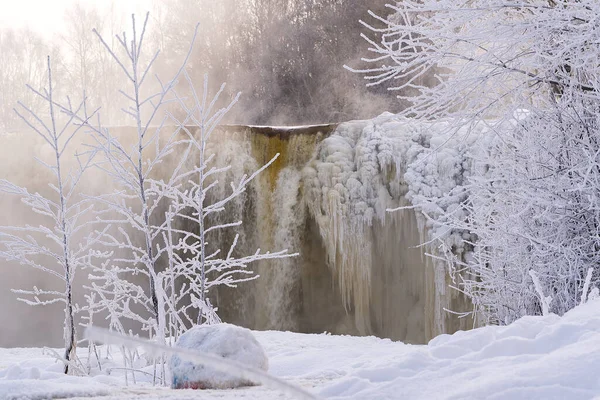 Zimą zamarznięty piękny wodospad Jagala pod światłami wschodu słońca, odbicie w rzece. Estonia. — Zdjęcie stockowe