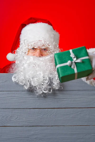 A Mikulás zöld ajándékdobozt tart a kezében. Karácsonyi értékesítési koncepció — Stock Fotó