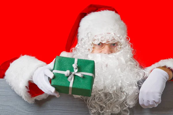 Der Weihnachtsmann hält eine grüne Geschenkbox in der Hand. Konzept Weihnachtsverkauf — Stockfoto