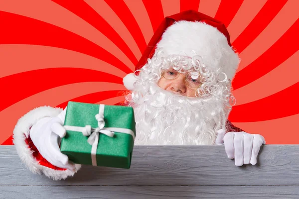 Papá Noel sosteniendo una caja de regalo verde en su mano. concepto de venta de Navidad — Foto de Stock