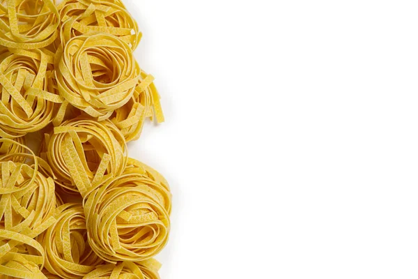 Fettuccine pasta italiana aislada sobre fondo blanco. Nidos crudos de tagliatelle aislados sobre fondo blanco. Pastas tradicionales italianas — Foto de Stock