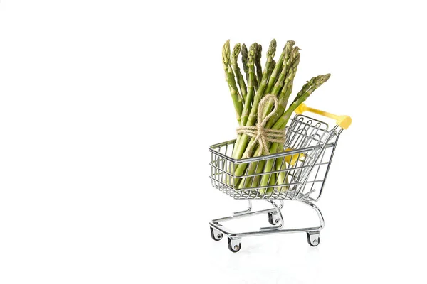 Espargos verdes frescos orgânicos no carrinho de compras isolado no fundo branco — Fotografia de Stock