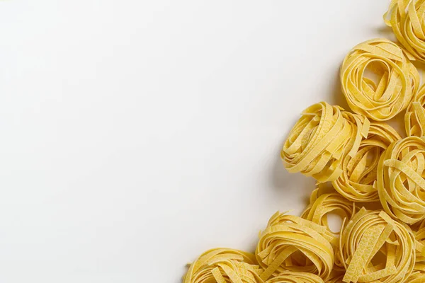 Fettuccine olasz tészta elszigetelt fehér alapon. Nyers tagliatelle fészkek elszigetelt fehér háttér. Hagyományos olasz tészta — Stock Fotó